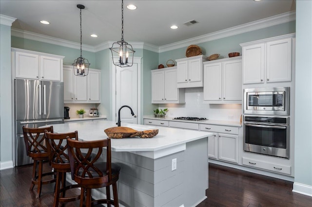 kitchen featuring visible vents, a kitchen island with sink, dark wood-style floors, stainless steel appliances, and light countertops