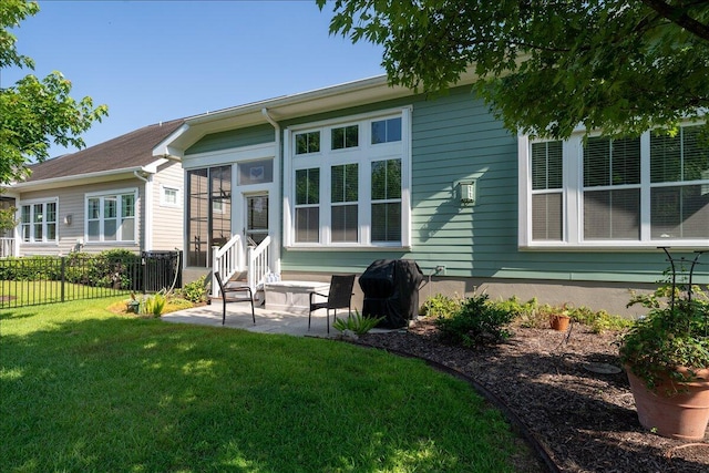 back of house featuring a patio area, a lawn, and fence