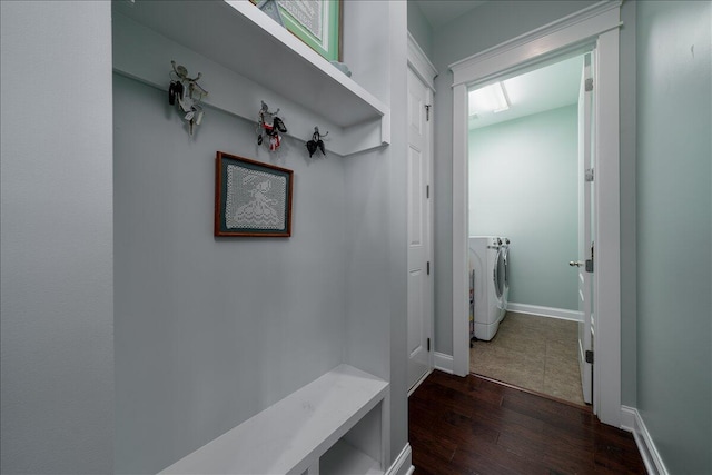 hall featuring washing machine and dryer, dark wood-type flooring, and baseboards