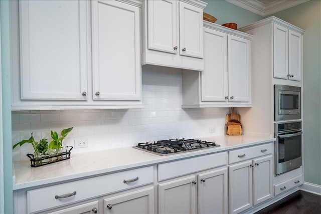 kitchen featuring white cabinetry, crown molding, tasteful backsplash, and stainless steel appliances