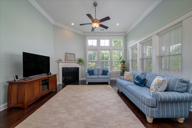 living area featuring dark wood finished floors, ceiling fan, baseboards, and ornamental molding