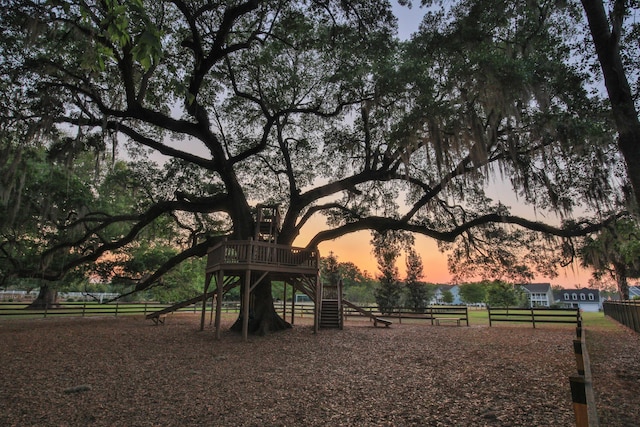 view of home's community featuring fence and playground community