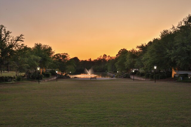 yard at dusk featuring a water view