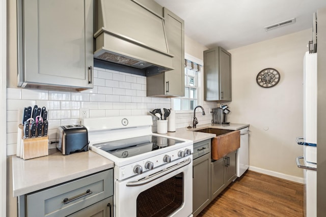 kitchen with sink, dark hardwood / wood-style flooring, white appliances, gray cabinets, and custom exhaust hood