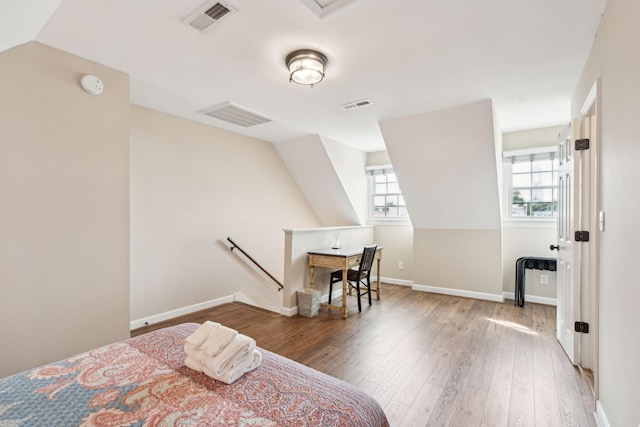 bedroom with wood-type flooring and vaulted ceiling