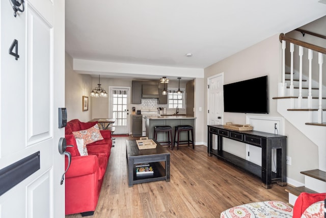 living room featuring sink, dark hardwood / wood-style floors, and a notable chandelier