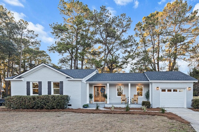 ranch-style home featuring a garage and covered porch