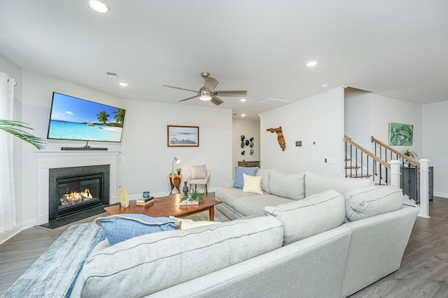 living room featuring ceiling fan and dark wood-type flooring