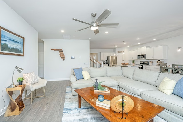 living room featuring light wood-type flooring and ceiling fan