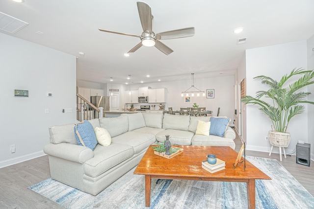 living room with ceiling fan and light hardwood / wood-style floors