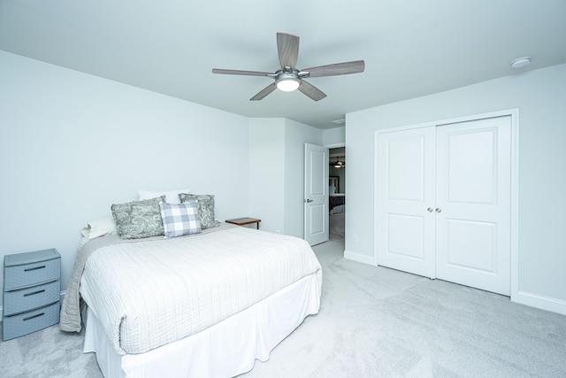 carpeted bedroom featuring ceiling fan and a closet