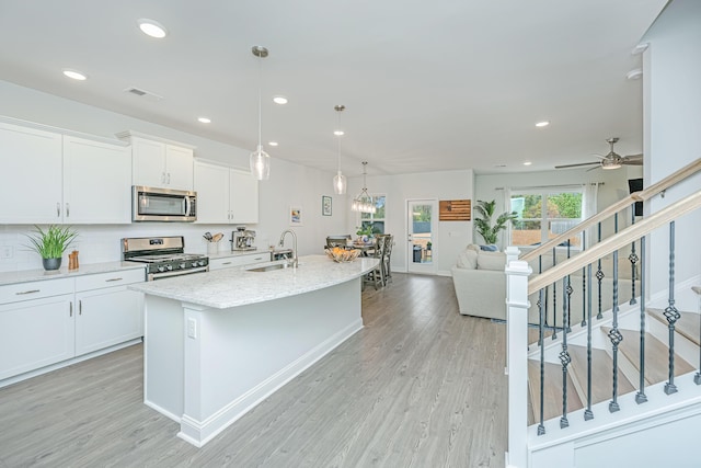 kitchen featuring sink, ceiling fan, light hardwood / wood-style floors, white cabinetry, and stainless steel appliances