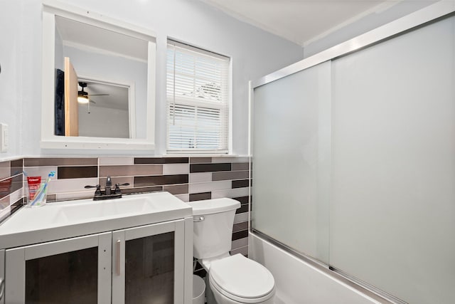 full bathroom with ceiling fan, tasteful backsplash, combined bath / shower with glass door, toilet, and vanity