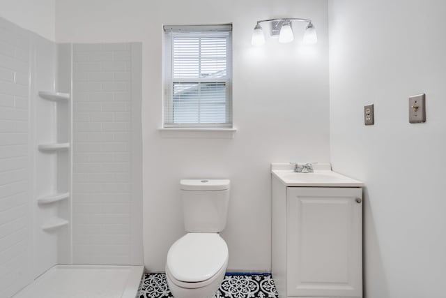 bathroom with tile patterned flooring, vanity, toilet, and a shower