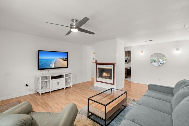 living room with ceiling fan and light hardwood / wood-style flooring