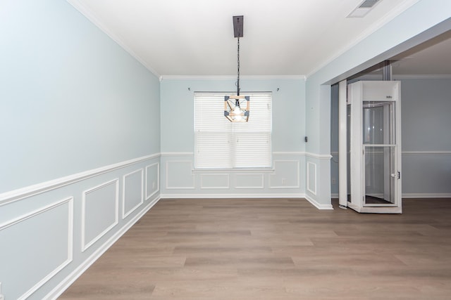 unfurnished dining area featuring light hardwood / wood-style flooring, an inviting chandelier, and crown molding