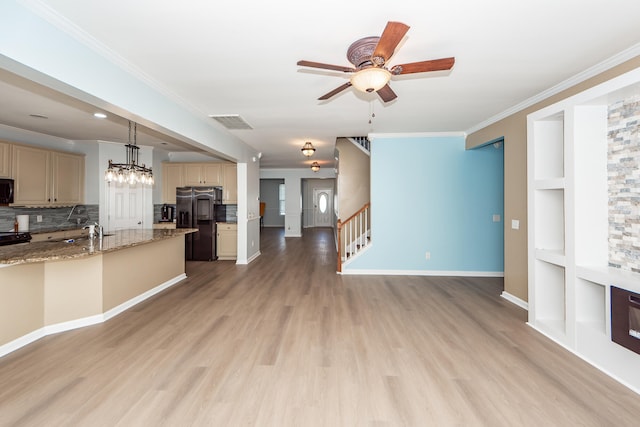 unfurnished living room with sink, ceiling fan, crown molding, built in features, and light wood-type flooring