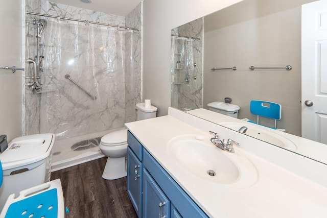 bathroom featuring walk in shower, vanity, toilet, and hardwood / wood-style flooring