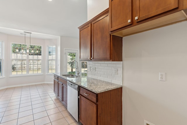 kitchen featuring light stone countertops, stainless steel dishwasher, sink, pendant lighting, and light tile patterned flooring