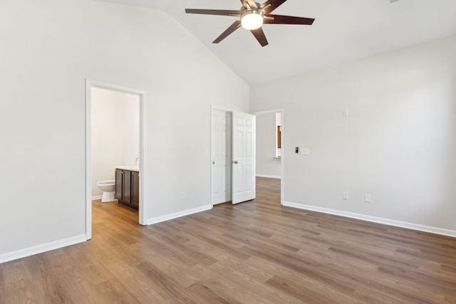 unfurnished bedroom featuring ensuite bathroom, high vaulted ceiling, ceiling fan, and light hardwood / wood-style floors