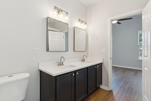 bathroom with ceiling fan, vanity, hardwood / wood-style flooring, and toilet