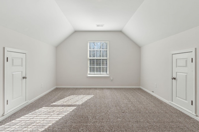 additional living space with light carpet and vaulted ceiling