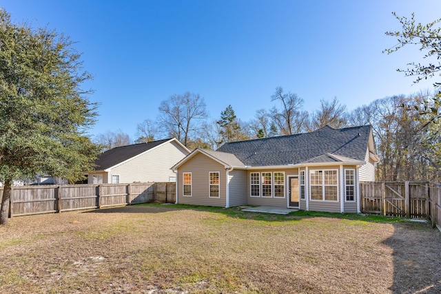 back of property with a yard and a patio