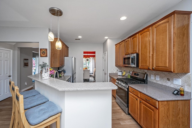 9636 Pebble Creek Blvd, Summerville, SC 29485 - kitchen with appliances with stainless steel finishes, light wood-style flooring, a peninsula, backsplash, and recessed lighting