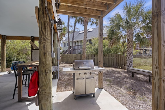 view of patio featuring a grill and fence