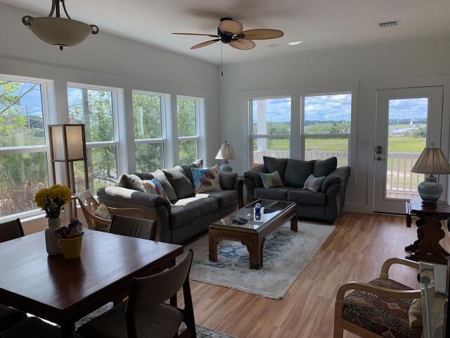 living area with ceiling fan, visible vents, and light wood-style flooring