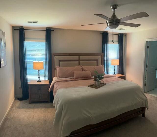 bedroom with ceiling fan and light carpet