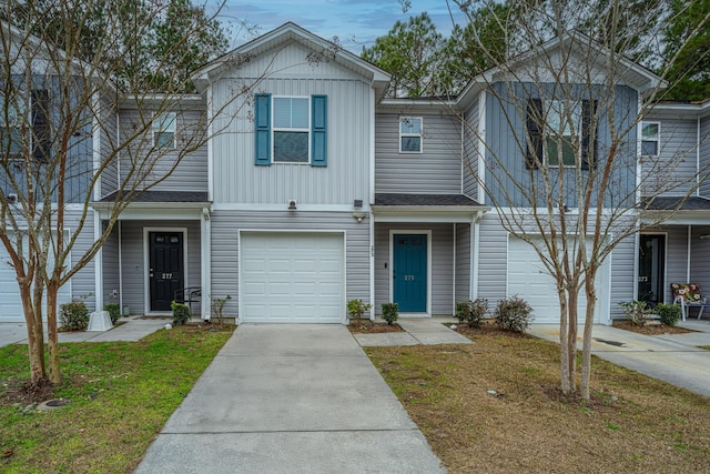 view of property featuring a front lawn and a garage