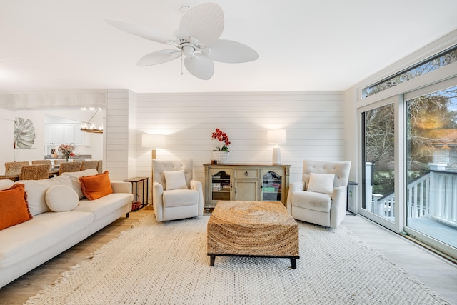 sunroom featuring ceiling fan with notable chandelier