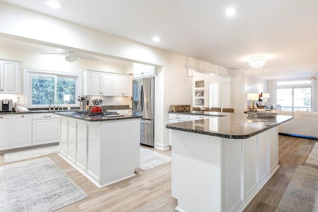 kitchen with ceiling fan, white cabinets, a center island, and stainless steel appliances