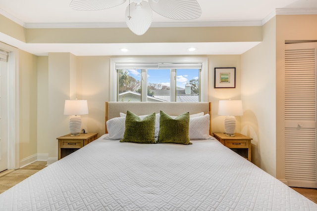 bedroom featuring ornamental molding, ceiling fan, light hardwood / wood-style flooring, and a closet