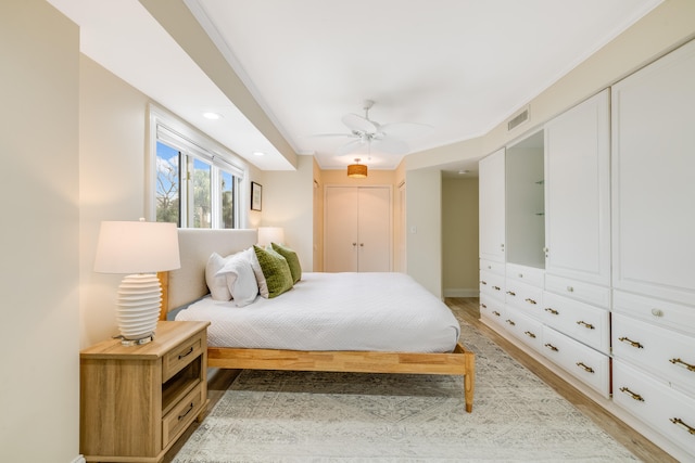 bedroom with crown molding, hardwood / wood-style floors, and ceiling fan