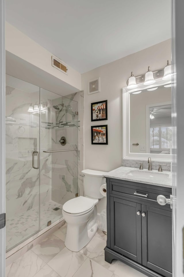 bathroom featuring a shower with shower door, toilet, and vanity