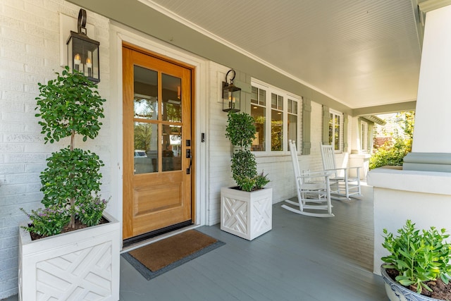 view of exterior entry featuring covered porch