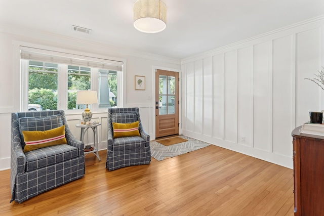 sitting room featuring crown molding, a healthy amount of sunlight, and light hardwood / wood-style flooring