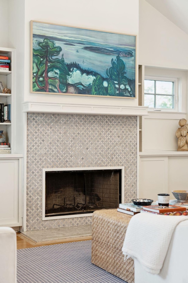 interior details with hardwood / wood-style floors, built in features, and a tile fireplace