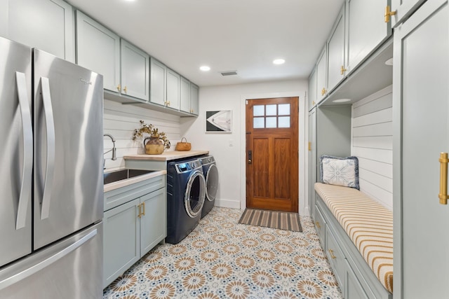 clothes washing area with washing machine and dryer and sink