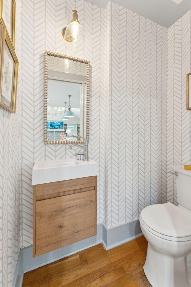 bathroom featuring vanity, hardwood / wood-style flooring, and toilet