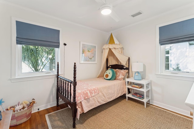 bedroom featuring multiple windows, ornamental molding, hardwood / wood-style floors, and ceiling fan