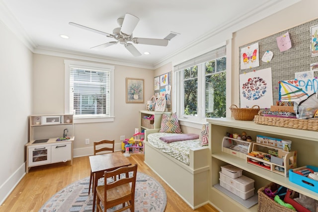 game room featuring crown molding, ceiling fan, and light wood-type flooring