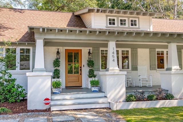 view of exterior entry featuring covered porch