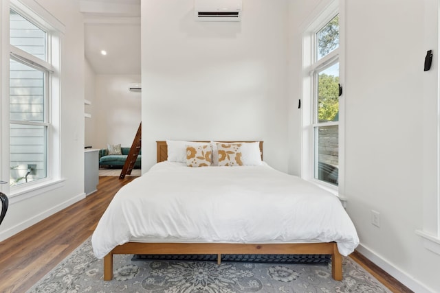 bedroom featuring dark hardwood / wood-style floors and a wall mounted AC