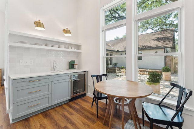 interior space featuring gray cabinets, dark hardwood / wood-style floors, sink, beverage cooler, and backsplash