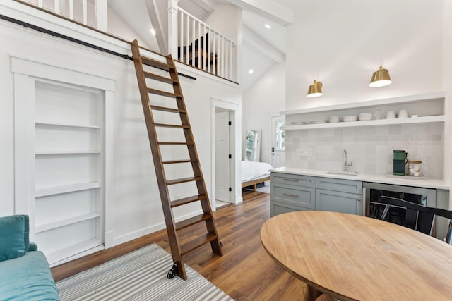 bar with wine cooler, sink, gray cabinetry, wood-type flooring, and backsplash