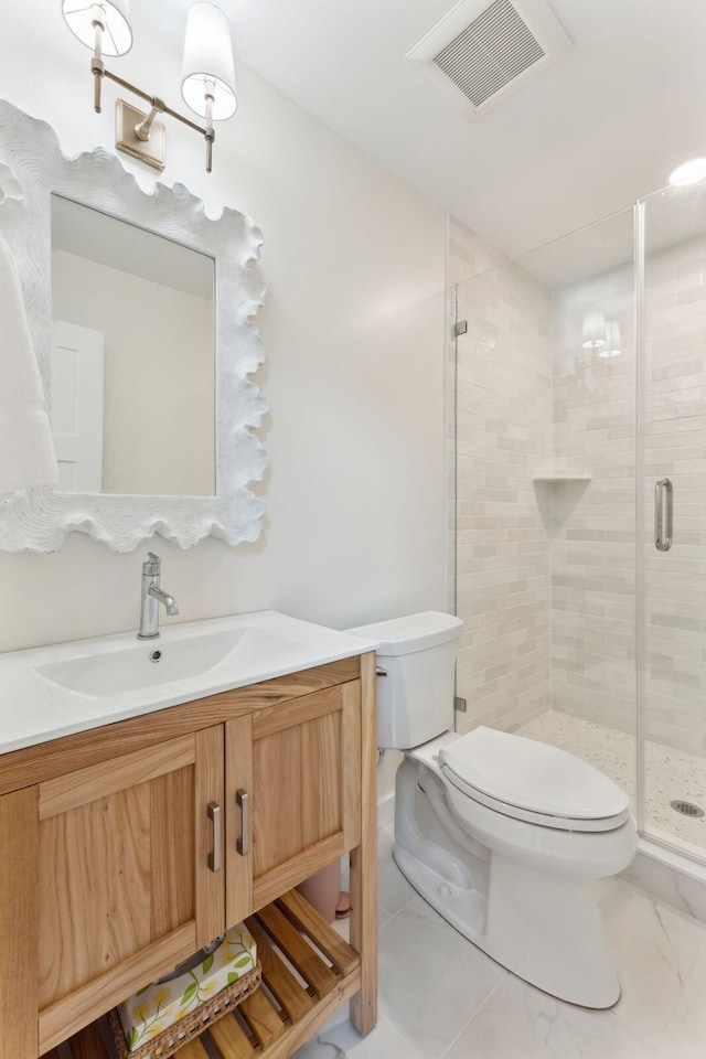 bathroom with vanity, toilet, and a shower with door