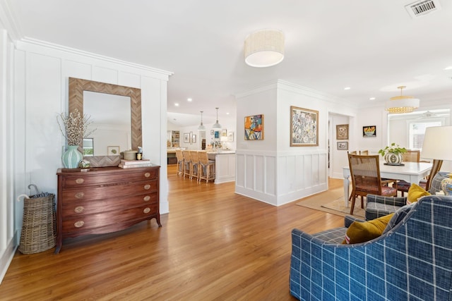 living room with wood-type flooring and crown molding